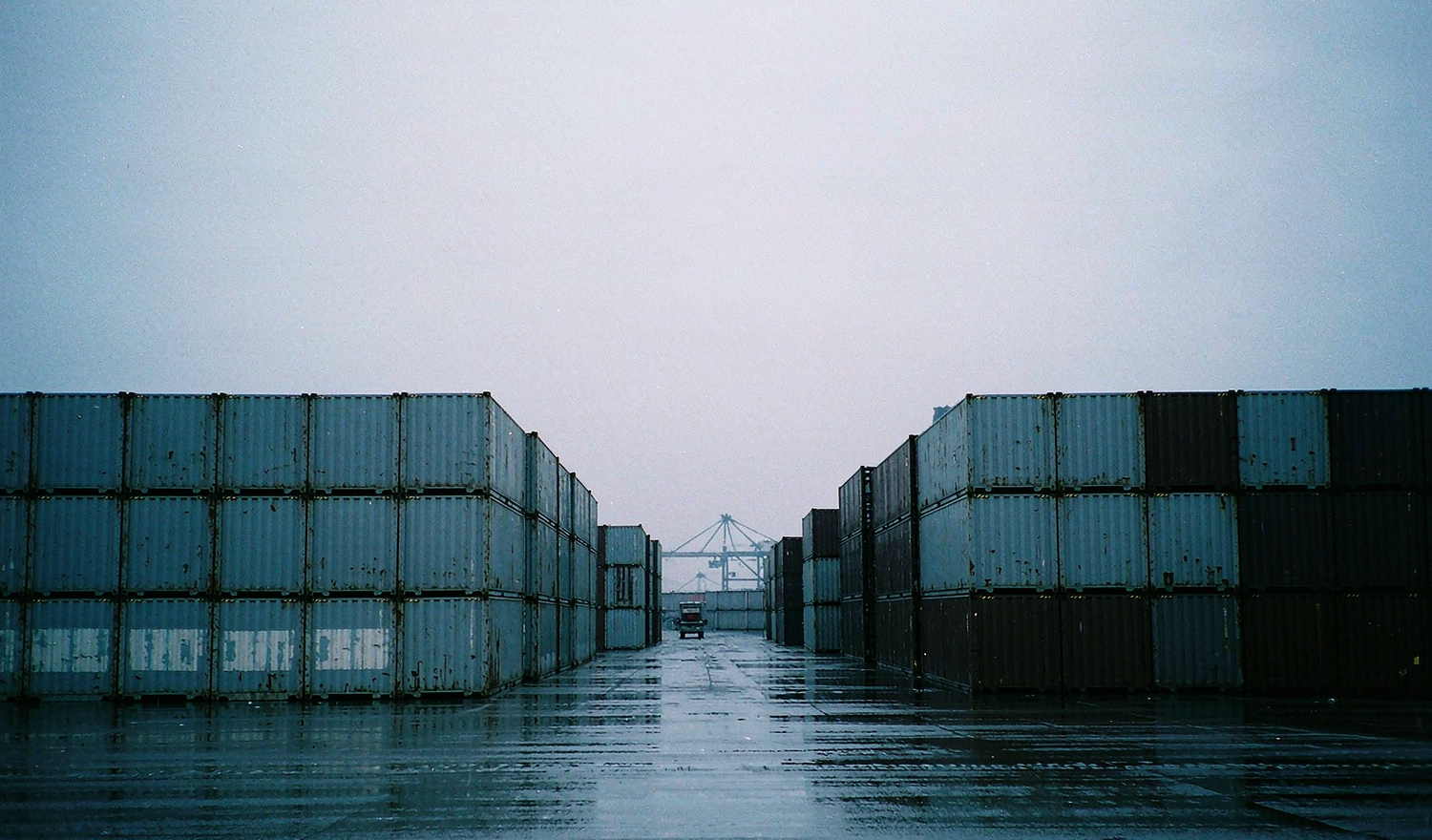 Stacked shipping containers at an export container yard on an overcast day