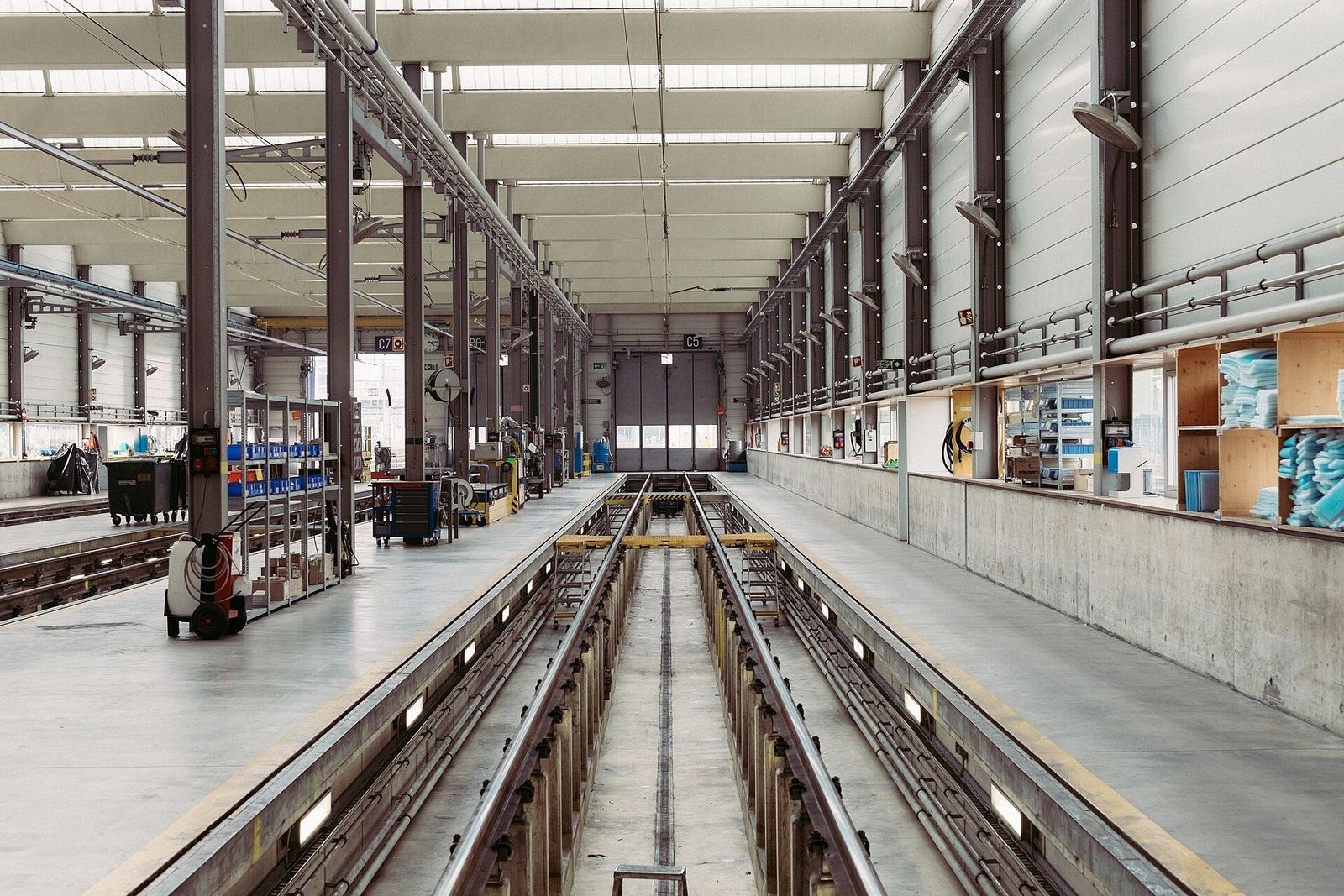 A long, quiet production hall with parallel assembly rails and workstations along both sides