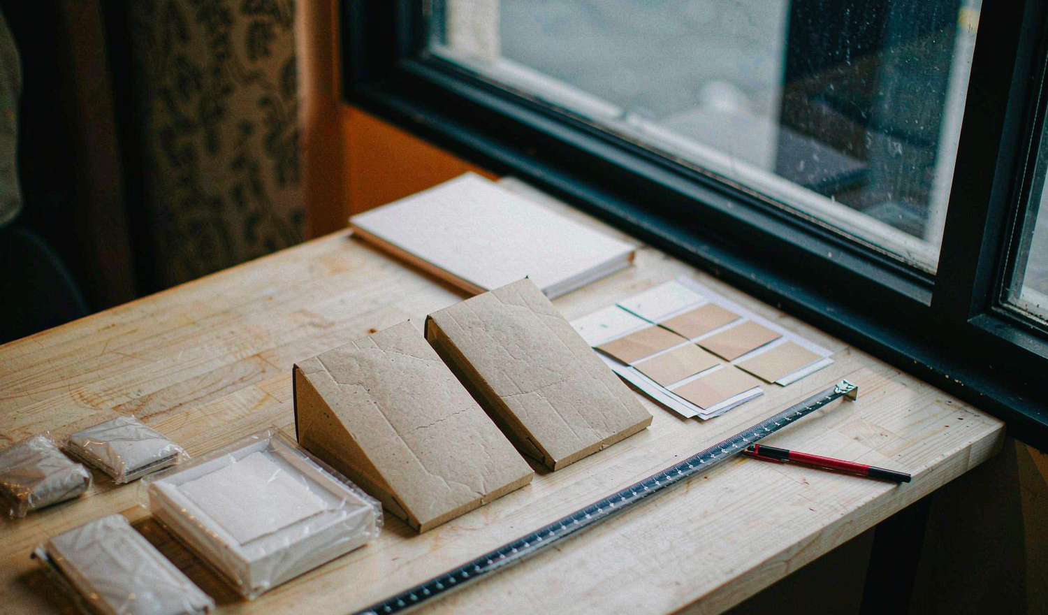 Product samples, packaging boxes and color swatches arranged on a working desk
